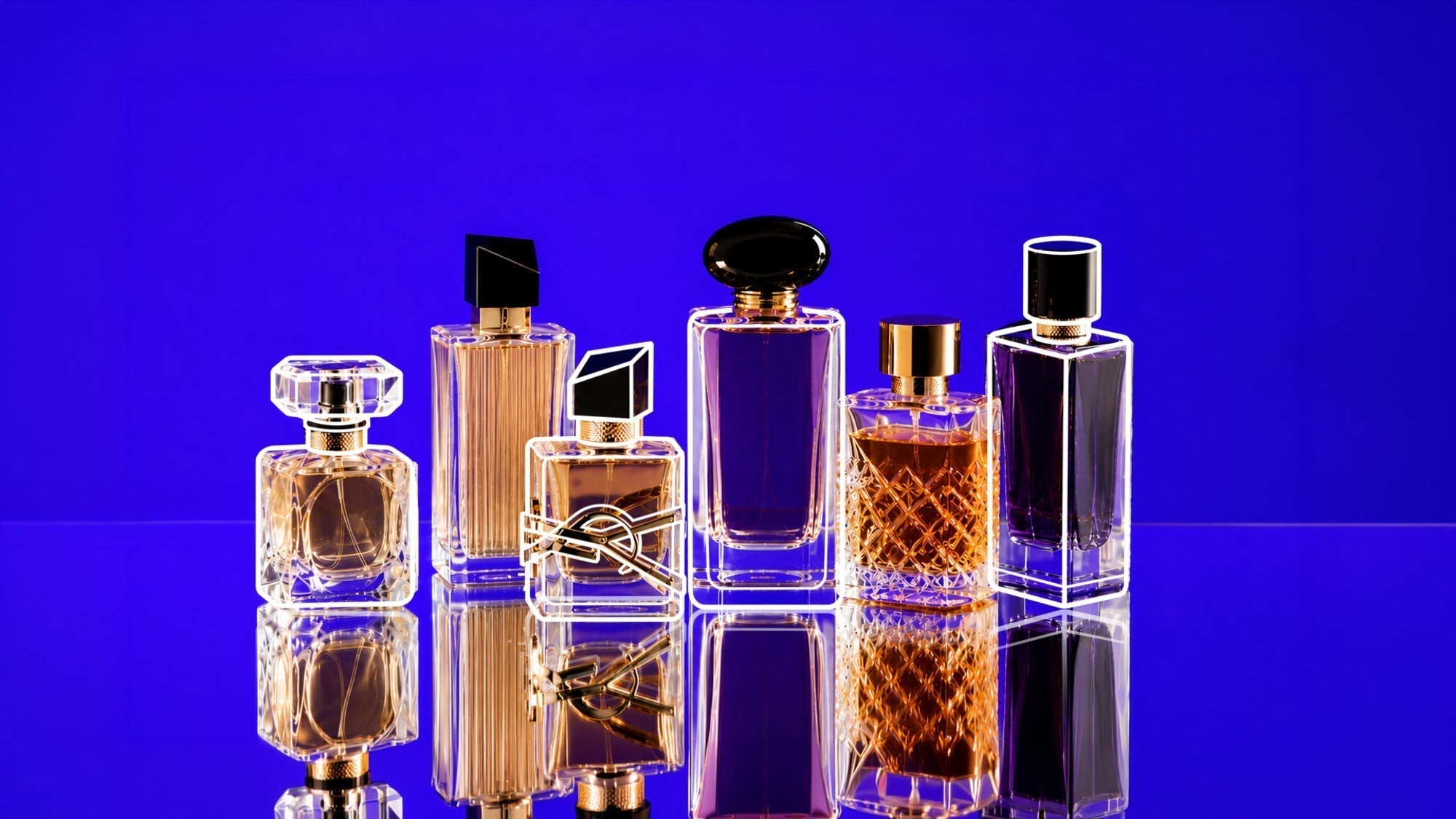 Collection of luxury perfume bottles with gold and black accents reflected on a glossy surface against a vibrant blue-purple background.
