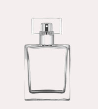 Clear glass perfume bottle with silver cap on a gray background